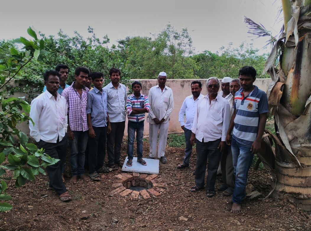 Mohan Anpat a social worker with villagers near the ground water recharge pit at Chinchani.